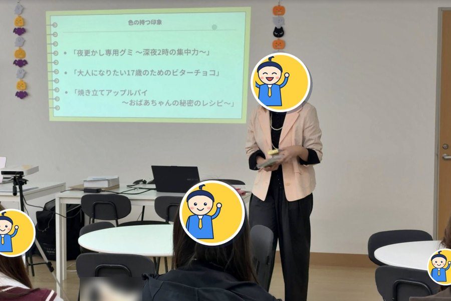 講師が「色の持つ印象」のスライドを使って、お菓子のパッケージと色について授業をしている様子