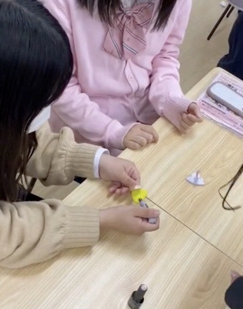生徒がネイルチップにネイルを塗っている手元