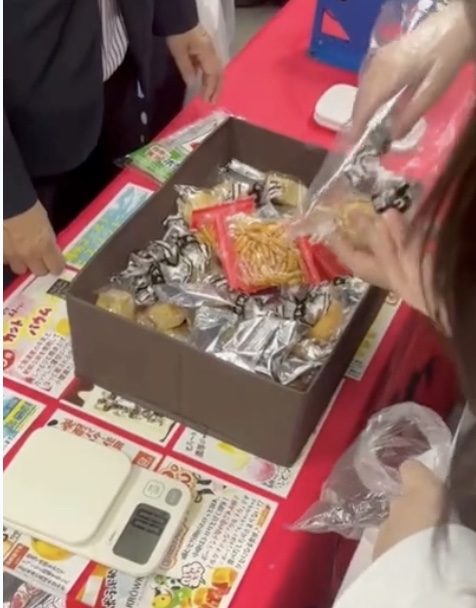 お菓子を計量して袋に詰める作業を体験している手元